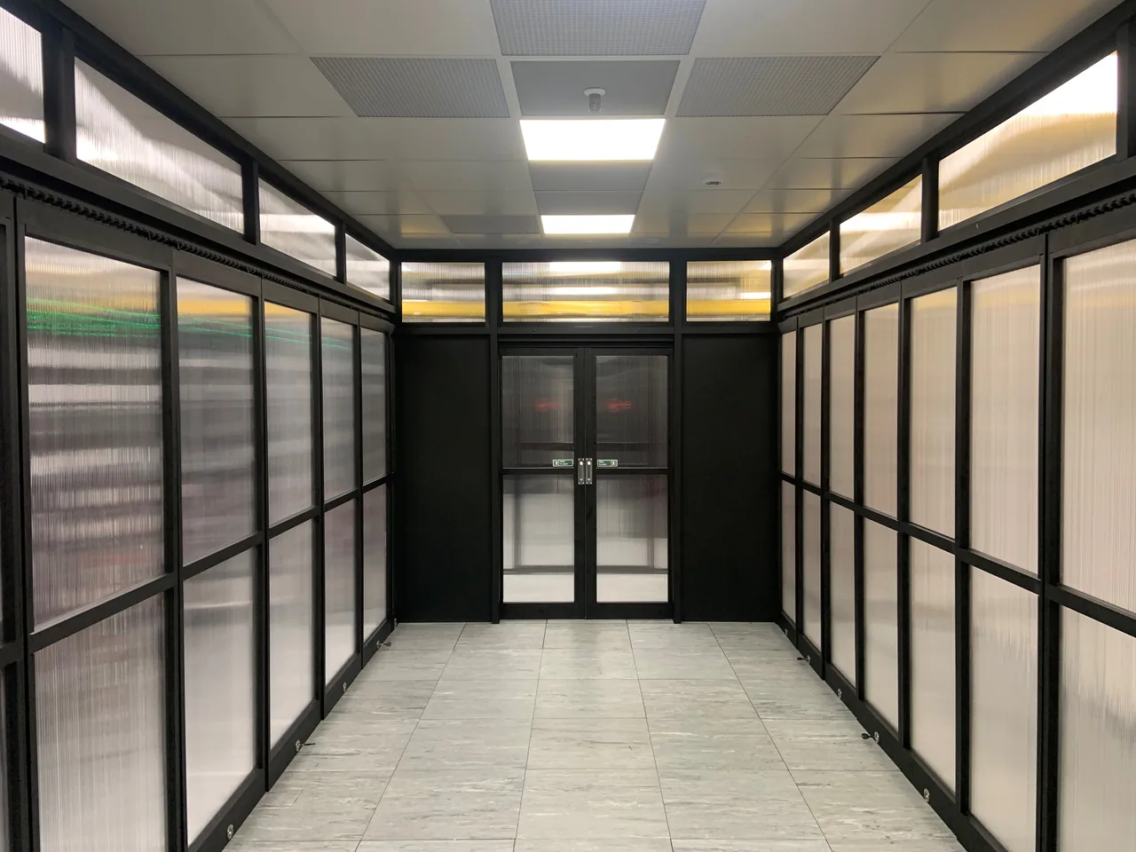 View down the inside of a containment enclosure with framed wall and ceiling panels