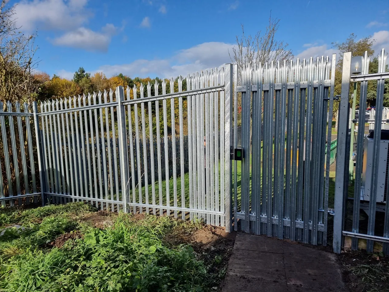 Galvanised palisade fencing and access gate around external equipment