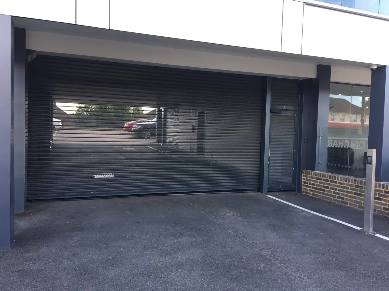 Mesh roller shutter across a covered car park entrance