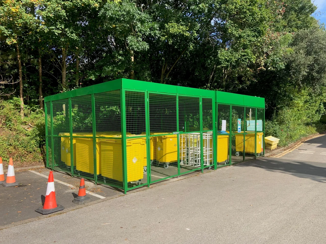 Green mesh enclosure and gates around outdoor storage bins