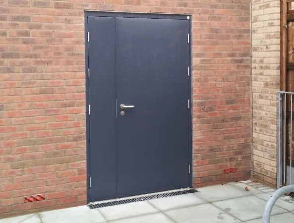 Dark steel door fitted in a brick opening
